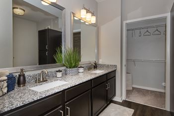 A bathroom with a large mirror and two sinks